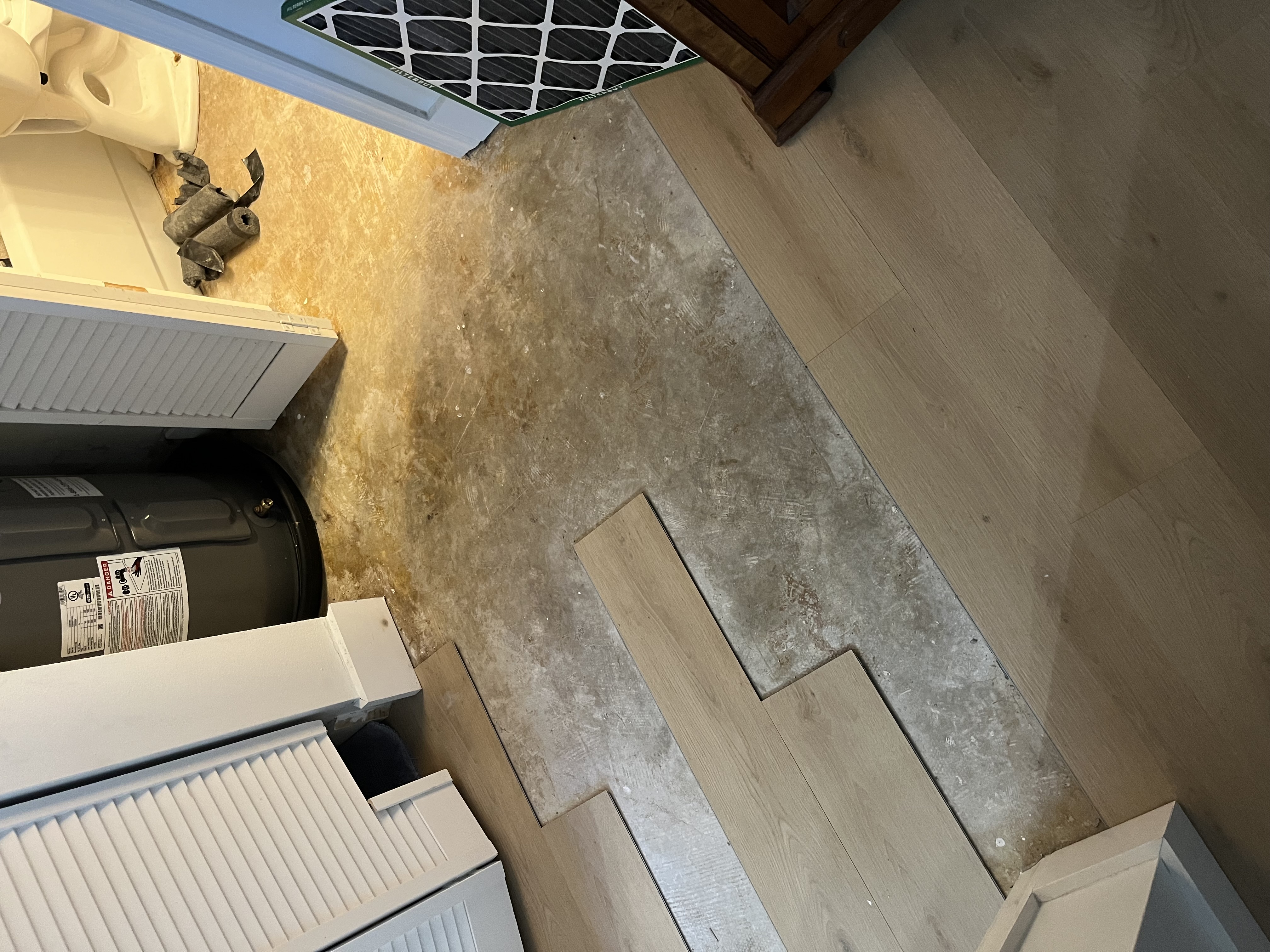 Walkway leading into the bathroom before the new flooring was fully installed