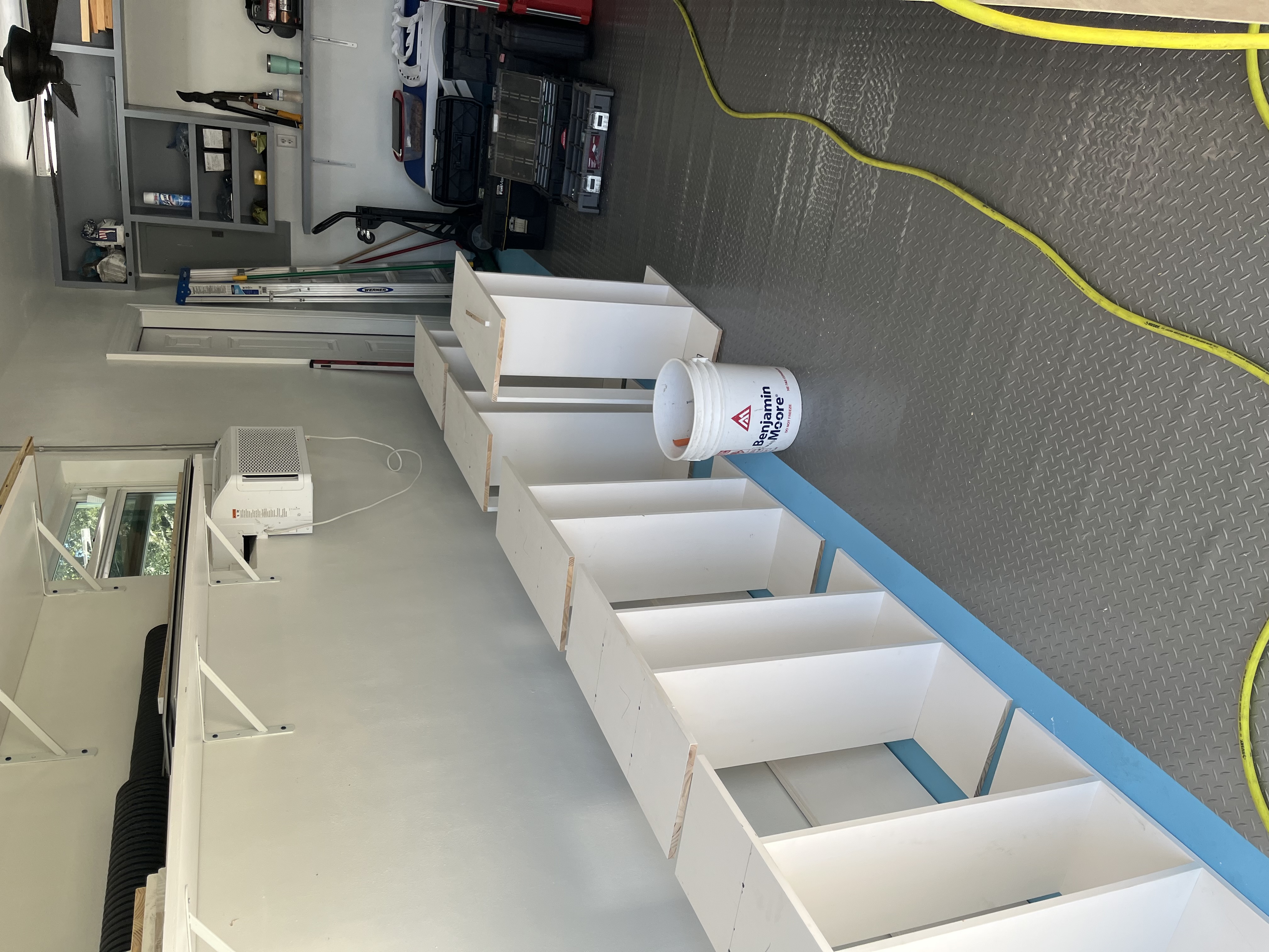 Built-in shelving cabinets partially assembled in a garage workspace