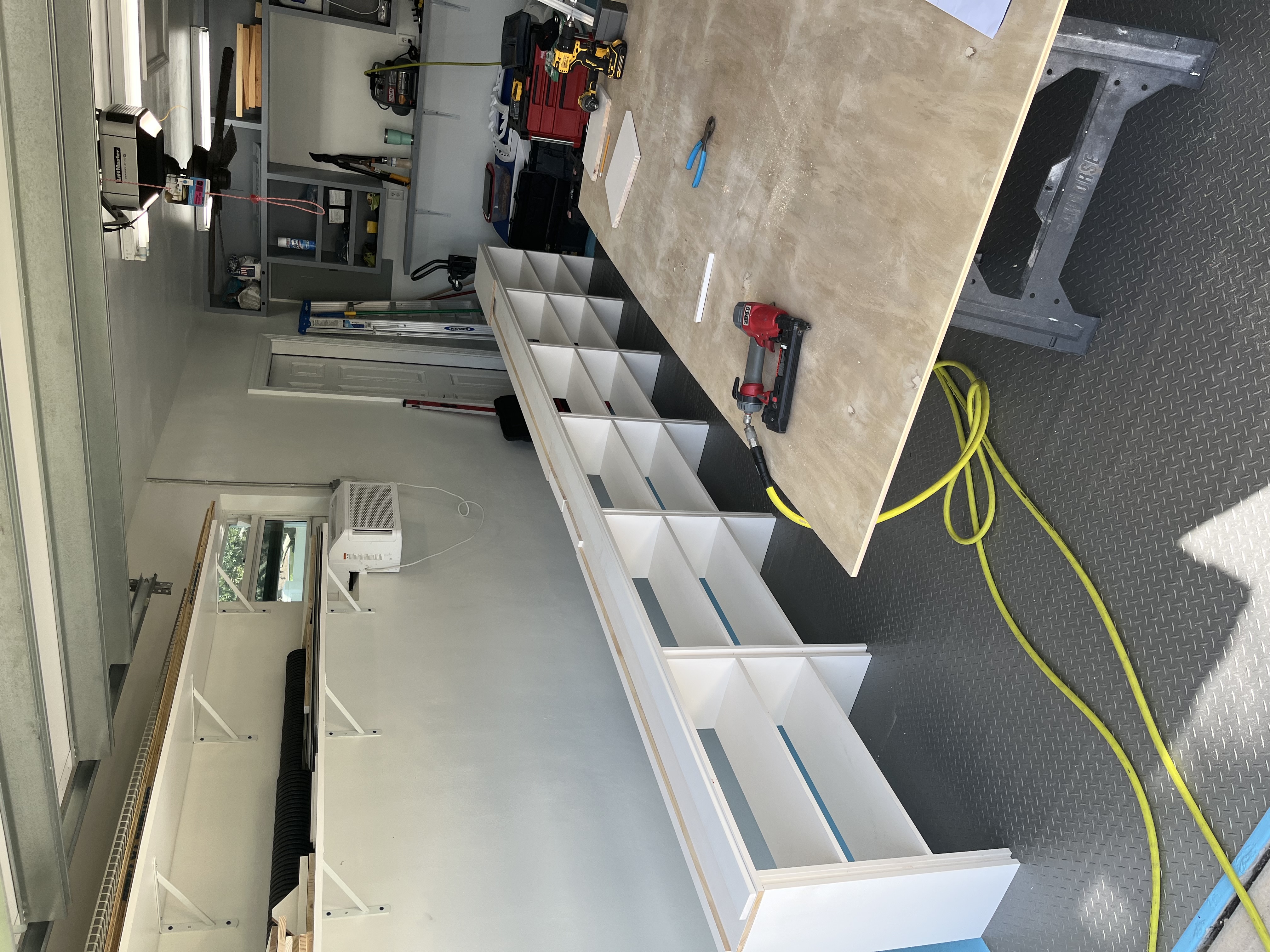 Long row of built-in shelving units assembled and lined up before installation