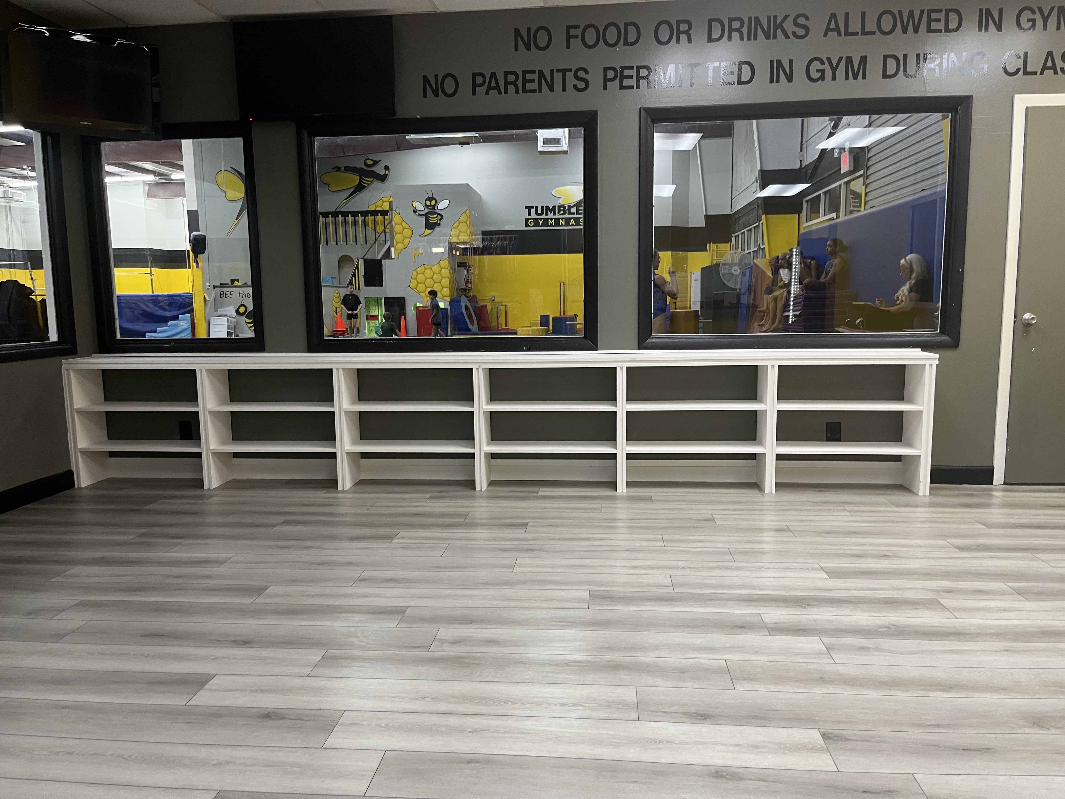 Finished custom built-in shelving installed along a wall in a gym space