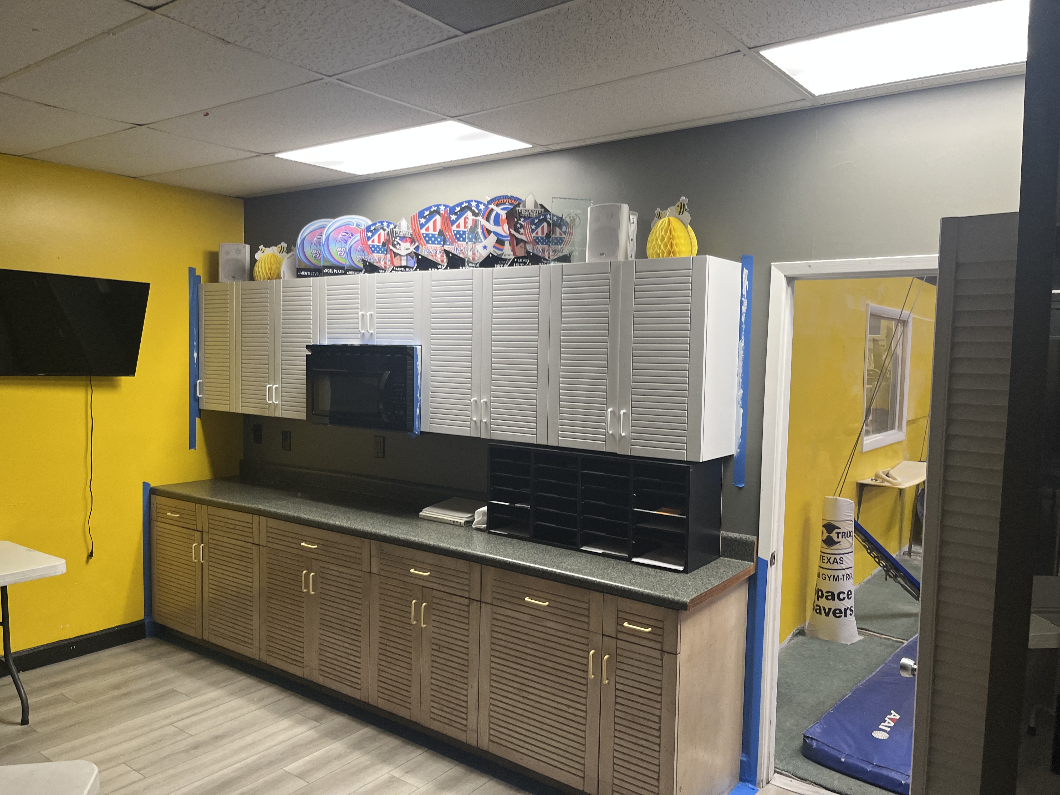 Before photo of darker cabinets in a gymnastics gym