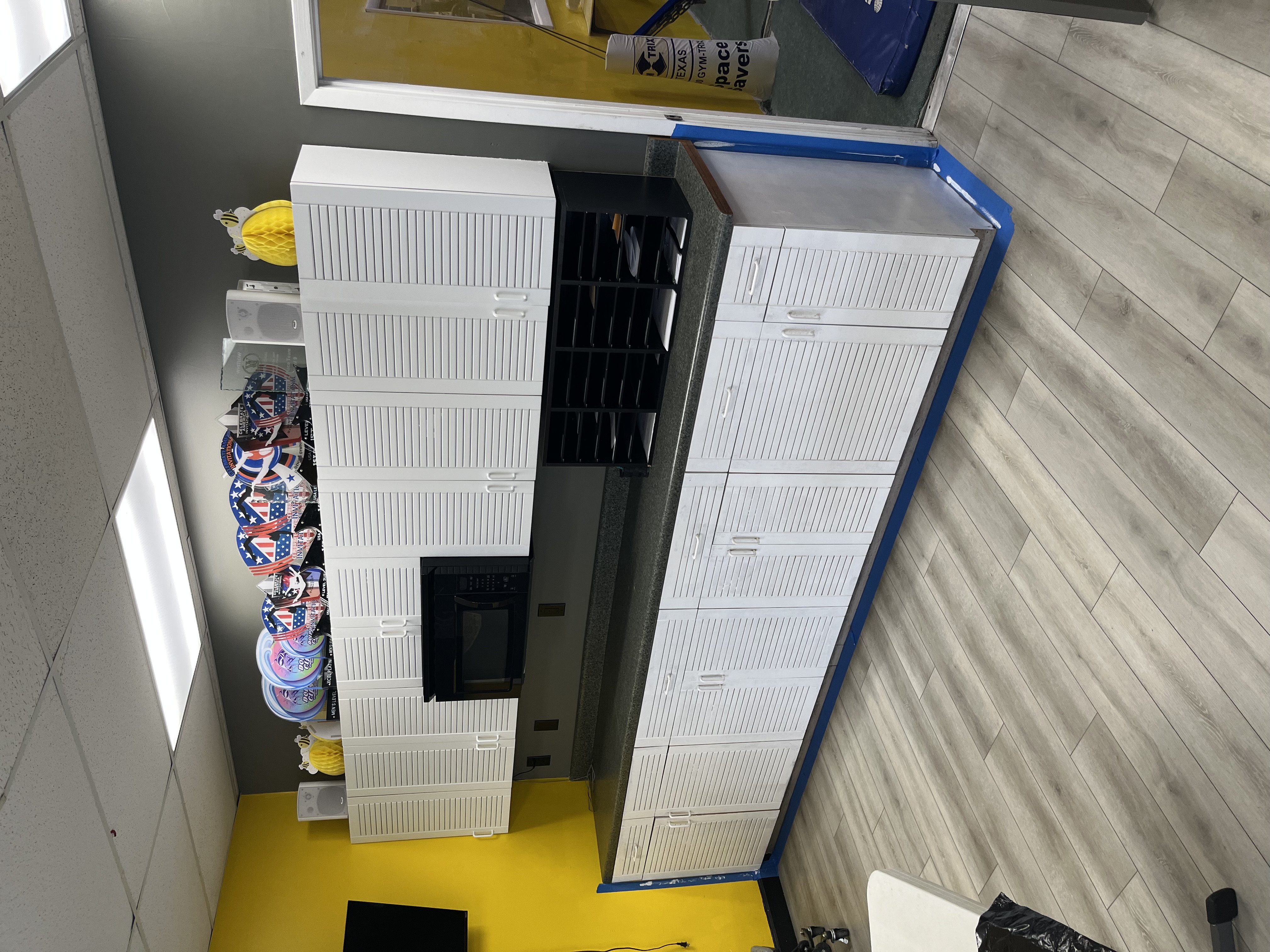 Finished gymnastics gym cabinet wall with white semi-gloss upper and lower cabinets