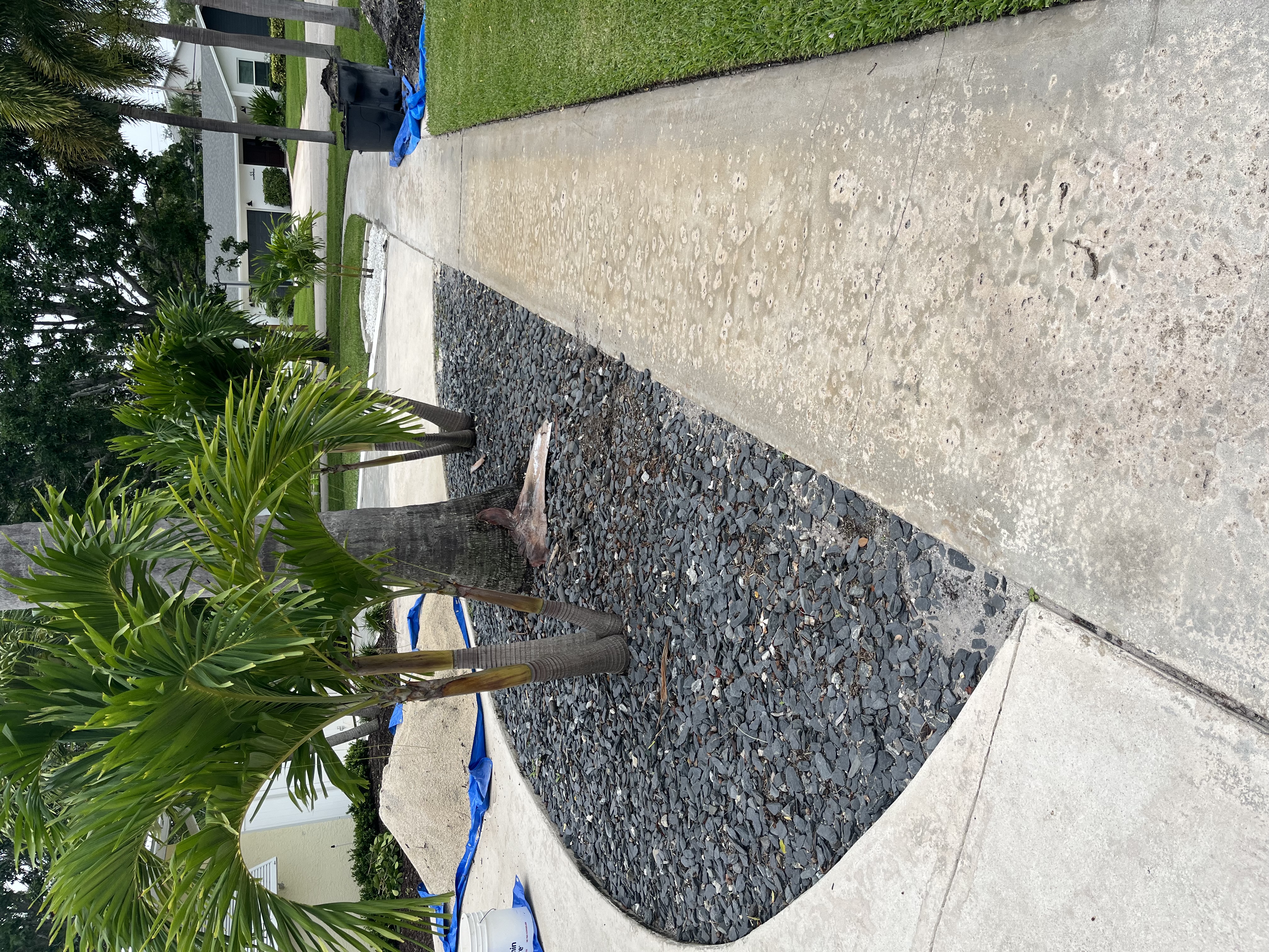 Front yard landscape bed filled with dark stone during the installation process