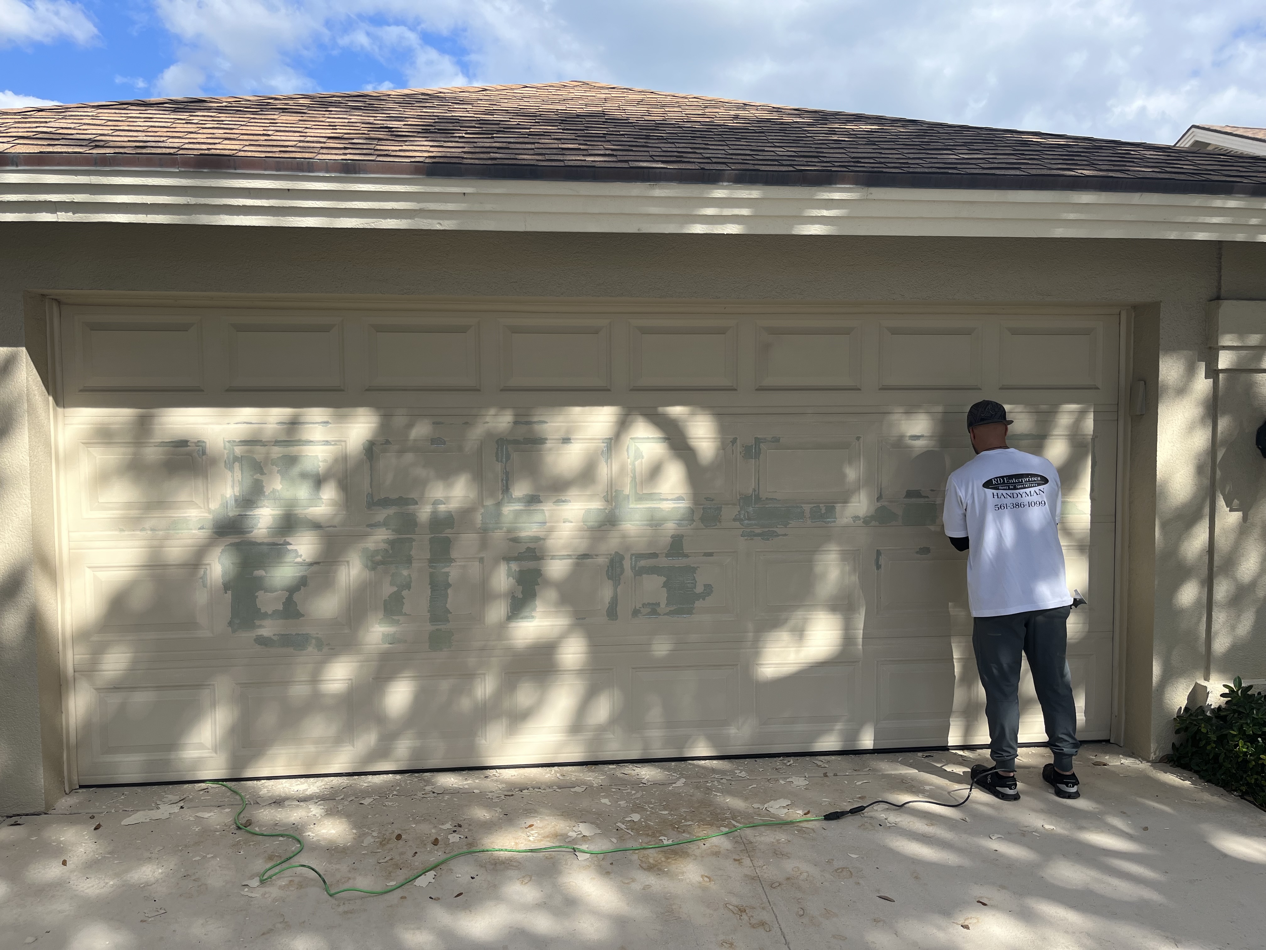 Garage door during early prep work with old finish being removed