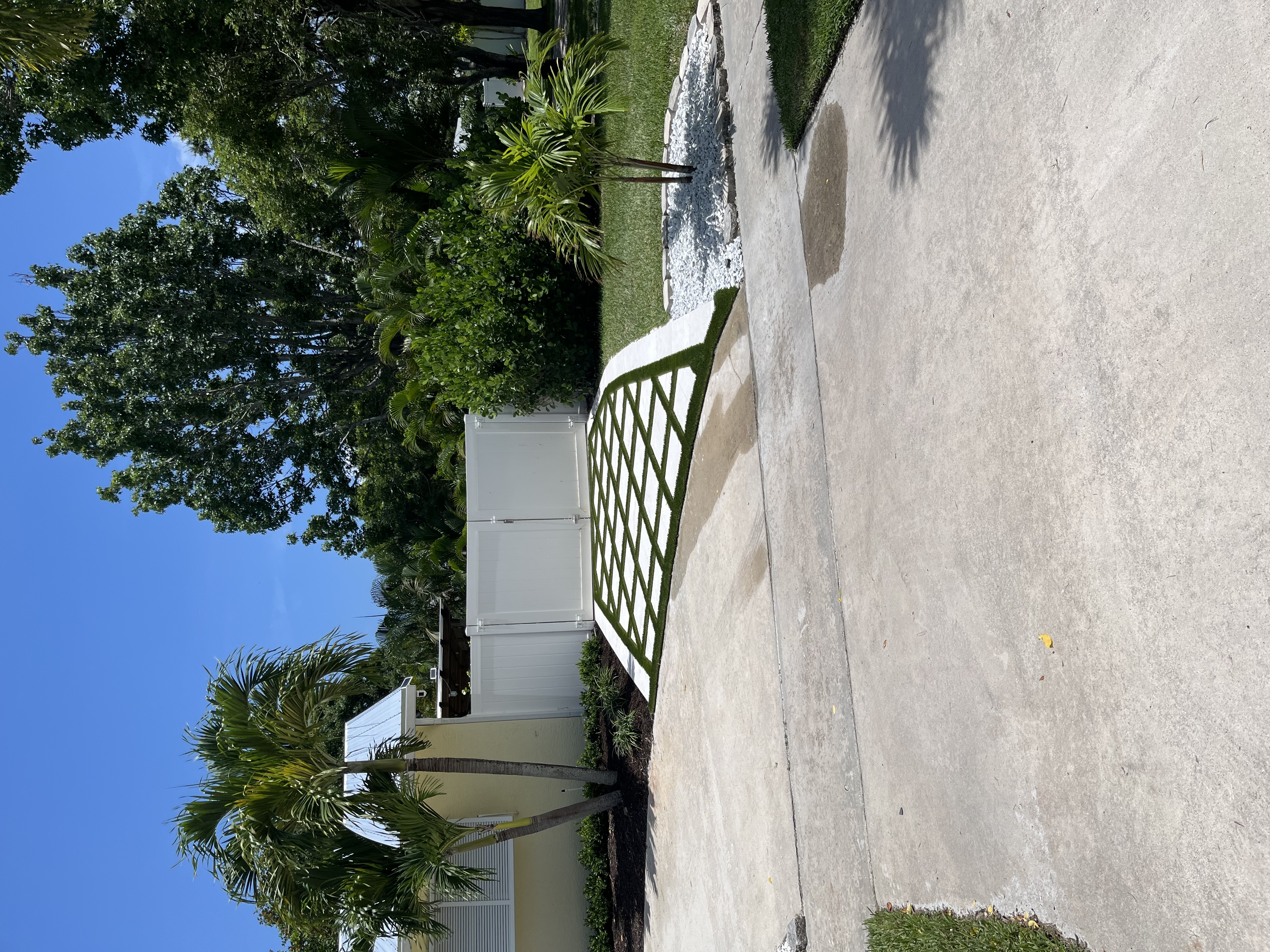 Finished driveway and side yard hardscape with a clean grass grid pattern and refreshed landscaping