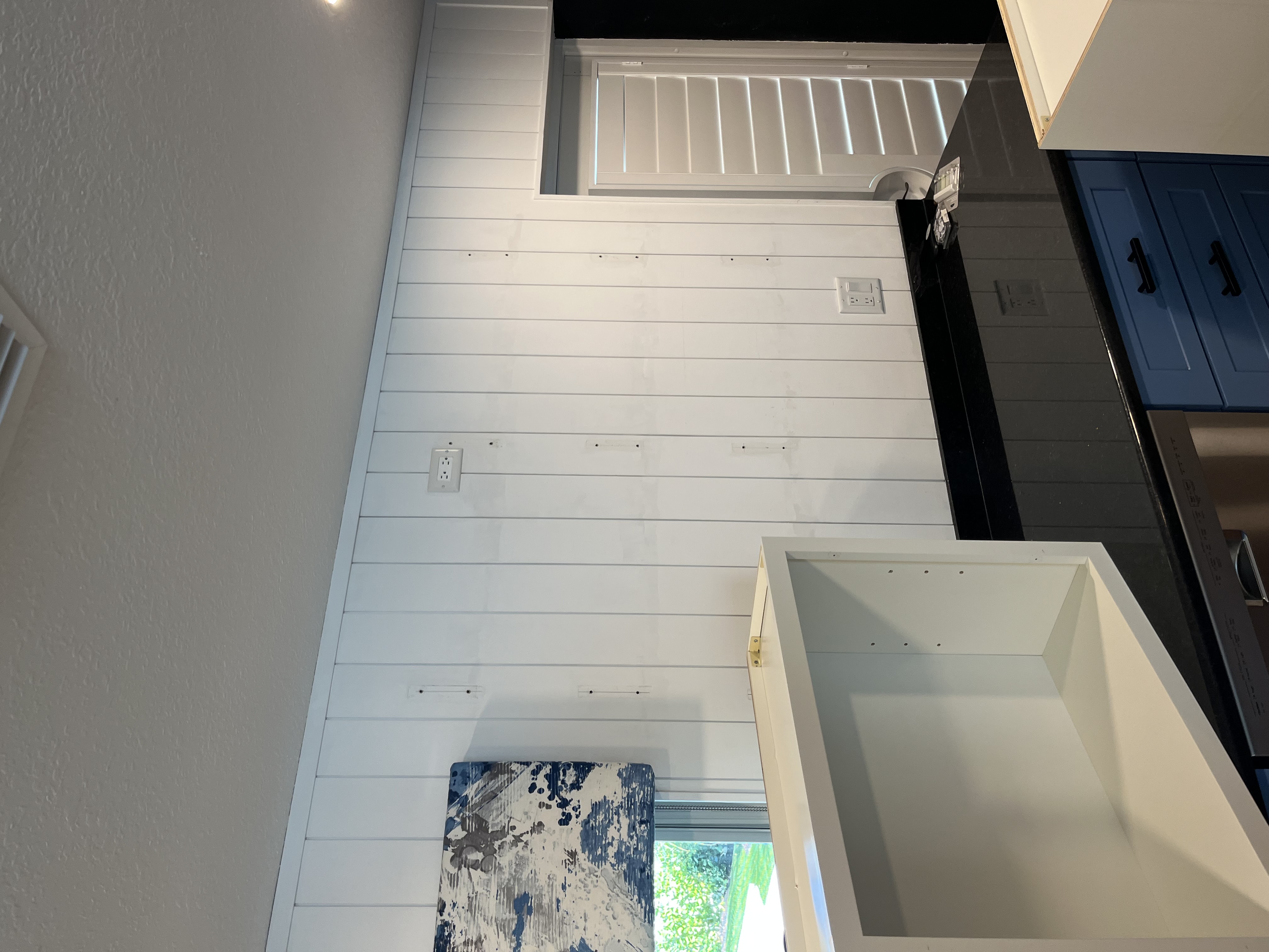 Kitchen wall paneling continuing across the side wall during installation