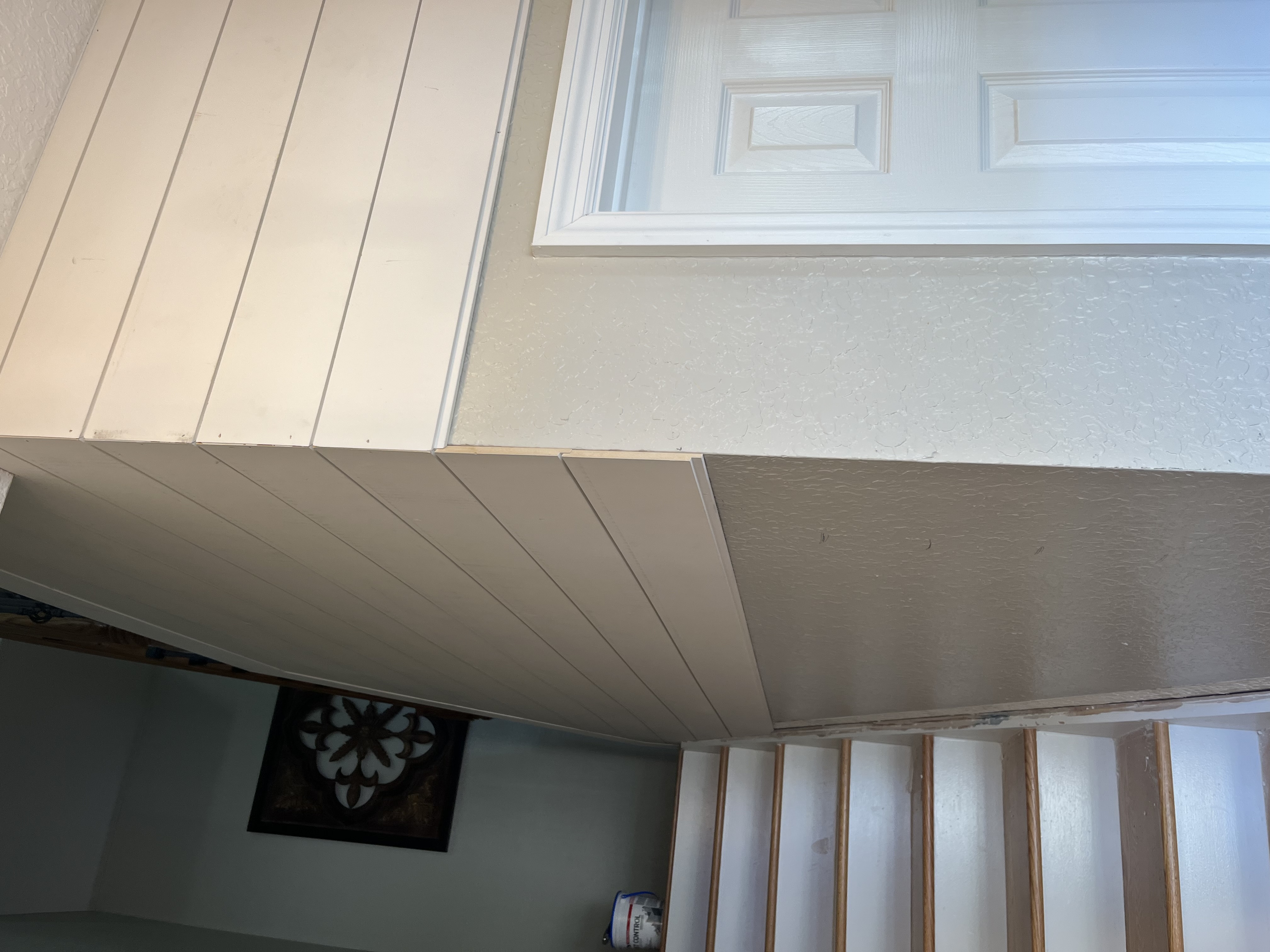 Stairwell paneling project with more completed trim and painted surfaces